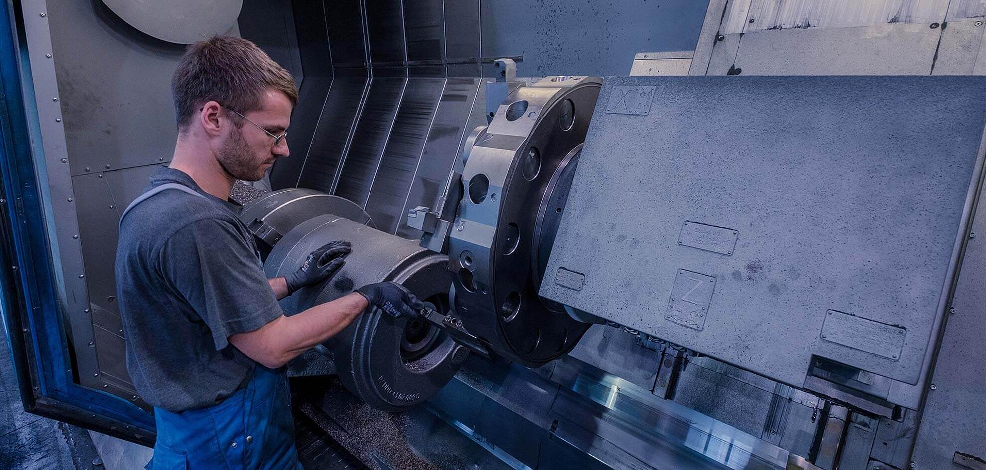 Ein Mitarbeiter arbeitet an einer großen Maschine mit Hebeln.
